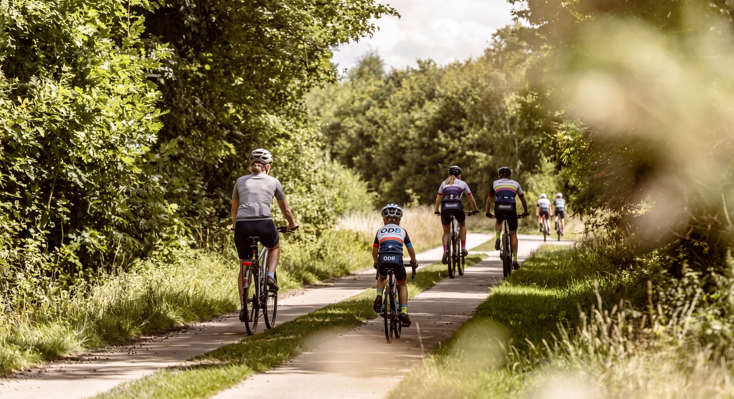 Groep fietsers op een landelijk fietspad tijdens de ODB Cycling Challenge
